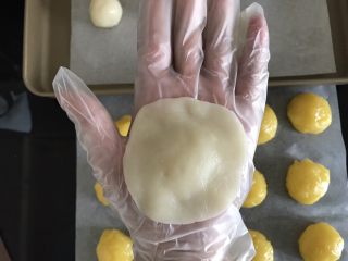 15、奶黄冰皮月饼,将冰皮压扁成中间厚周围薄的圆片,包上奶黄馅
