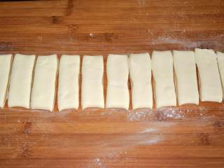 12、家常油条怎么炸 老师傅分享的方子 让你在家轻松做出好吃的油条,切成宽约2厘米的条状。