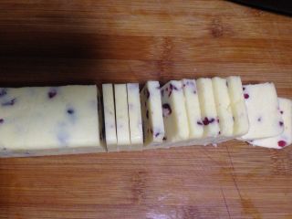 11、蔓越莓曲奇饼干,将冻好的面团从冰箱中取出，切厚度约0.5cm的片，烤箱预热180度