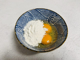 2、芒果披萨,鸡蛋打入碗中加入一勺面粉