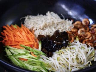 9、海虾什锦凉拌菜,把胡萝卜丝、黄瓜丝、焯水的绿豆芽、金针菇和木耳也放入锅中