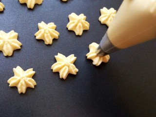 9、樱花????蛋黄小饼干,在不粘烤盘上挤出面糊 如果烤盘很粘需要垫一张油纸防粘