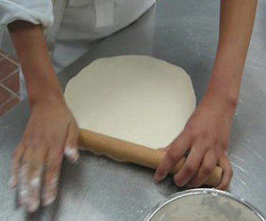 2、意大利风味比萨,将面团擀成中间薄边后的面片就好,为了防止成品的口感不够酥脆