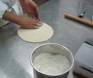 3、意大利风味比萨,擀制好后用手将比萨饼边收圆,备用