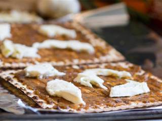 3、泰式无酵饼披萨,烤箱预热好之后，把无酵饼 放在垫好锡纸的烤盘上，抹上杏仁酱，放上新鲜马苏里拉 片或丝，烤7-10分钟至芝士融化。