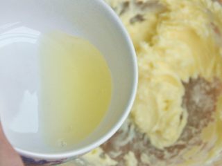 4、黑芝麻饼干,倒入一半的蛋清，让蛋清与黄油充分打发。