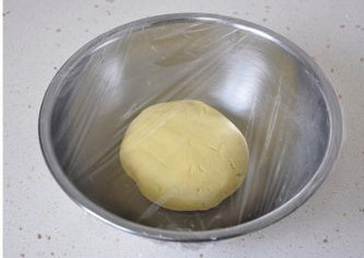 3、萌媚酥香的玛格丽特饼干,用保鲜膜将面盆裹严实，放冰箱冷藏1小时左右，这样回头造型时会有很好看的裂纹。