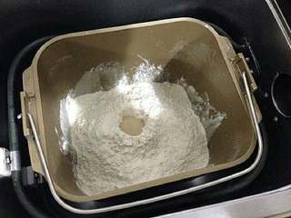 2、【培根菠萝披萨】,用后油法把除黄油外的材料按顺序纯牛奶、鸡蛋、盐、糖、高粉、酵母粉加入面包桶内，启动和面程序。