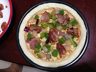 9、【培根菠萝披萨】,上面再铺上培根、洋葱、青椒。