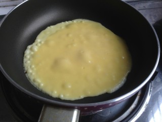 6、虎皮三明治,不粘锅里放一勺蛋奶糊，中小火煎大概一分钟，表面起很多泡泡，翻面。