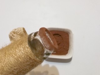 9、蘑菇饼干,再找个空碑酒瓶，把瓶嘴在可可粉半沾满一圈；（我家没有空瓶，这个是我以前用空碑酒瓶做的插花瓶，临时救急了）
