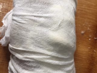 14、夏日凉菜—白切猪肘,用纱布包裹用绳子扎起来，在用重物压住4小时即可放入冰箱冷藏，主要是去除一部分汤汁油脂和让肉质更紧实，你也可以用保鲜膜包裹成圆形放入冰箱冷藏