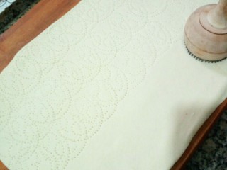 4、美式披萨,面坯根据烤盘大小擀开,用馕针或牙签扎上气孔。