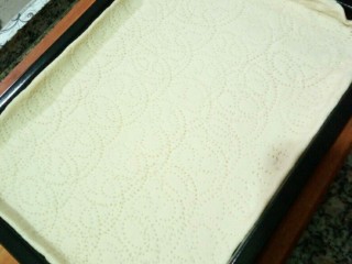 5、美式披萨,将饼坯放入烤盘调整均匀