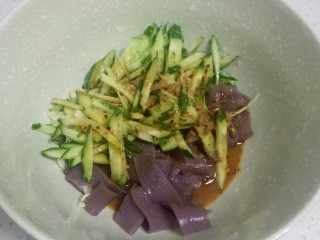 15、不用洗面的黑米凉皮,把切好的凉皮、黄瓜丝、蒜末放入碗里，加入调好的料汁。