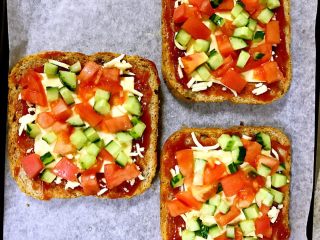 6、全麦核桃吐司披萨,将切好备用的黄瓜丁、西红柿丁平铺在芝士片上（也可放入蘑菇、青椒、红椒）