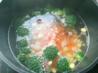 7、西兰花培根披萨,锅里烧开水，放入玉米粒和红萝卜丁，还有西兰花，加点盐，焯熟