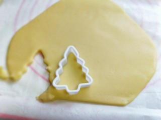 10、圣诞树饼干#预热圣诞节#,用模具压出圣诞树????，小心去掉周边的面片，去掉的面片还可以重复步骤再次擀圆饼再压出圣诞树????。