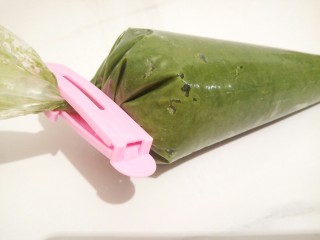 10、云朵抹茶曲奇,用手揉裱花袋里面的面糊，让空气挤出来，利于裱花，把封口拧紧，用封口夹子夹好（裱花的时候面糊不会往上跑）