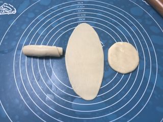 11、榨菜鲜肉月饼,取第一个包好的面团用手掌摁一下，然后用擀面杖擀成长舌状，要从中间分别往上下擀开，由上至下卷起，保鲜膜盖好，