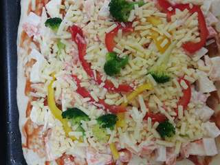 4、水果披萨,烤箱预热，发孝面饼放入烤箱烤八分熟，取出考好的饼放凉后抹上一层番茄酱，在把全部的配料均匀的覆盖好，放入烤箱七八分即可。