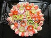 5、海鲜批萨,在饼面上用叉子扎些洞,抹上番茄酱,放上芝士,然后放上青红椒、洋葱、火腿