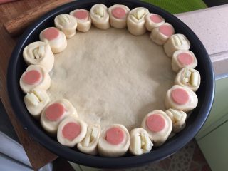 6、这样吃披萨才爽——重芝士火腿边披萨,再将火腿小段和奶酪小段整齐排列组合一圈，如图