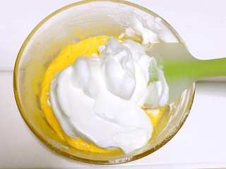 5、宝宝辅食之手指饼干,将一半的蛋白加入蛋黄糊中，轻轻的用上下切拌的手法翻拌均匀。