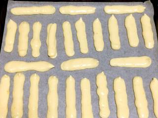 10、宝宝辅食之手指饼干,将裱花袋剪个小口，挤到烤盘上。