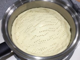 2、至尊海陆披萨,平底锅预热涂黄油，面团擀开，放入锅内，叉子叉小气孔。