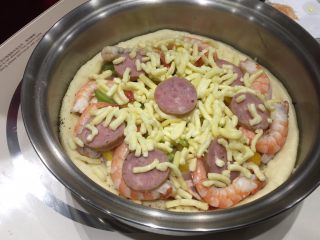 3、至尊海陆披萨,依次放黑胡椒、蕃茄酱、蘑菇、洋葱、马苏里拉芝士1/3、青椒和黄椒、香肠、虾、剩余2/3马苏里拉芝士。