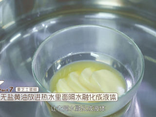 4、烤蓝莓重芝士蛋糕,接着我们来做重芝士蛋糕的部分,把重芝士蛋糕中的无盐黄油放入热水里面隔水融化成液体