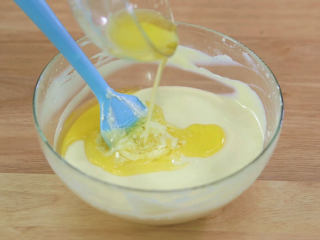 10、烤蓝莓重芝士蛋糕,接下来的步骤,不需要电动打蛋器了,全部换刮刀操作,因为芝士糊越来越稀了,用打蛋器,会把很多大泡泡打进去,烘烤的时候就会过度膨胀以及蛋糕里面有气孔,把融化成液体的无盐黄油全部加入芝士糊中用刮刀画圈圈拌匀