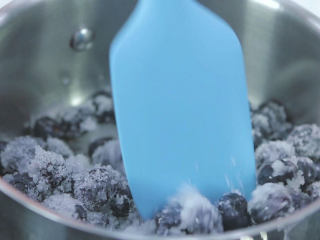 16、烤蓝莓重芝士蛋糕,然后把蓝莓和柠檬汁以及一般的细砂糖倒入奶锅中混匀一下,让每颗蓝莓都裹上一点砂糖,接着开大火,把蓝莓煮沸,期间不断的用刮刀拌匀,直到蓝莓渗出许多蓝莓果汁,细砂糖融化,那些蓝莓过的颗粒不要用刮刀去压,这样的果酱更有口感