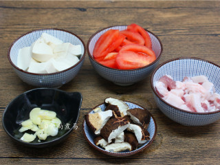 3、大杂烩一品煲,豆腐切块、番茄去皮切块、五花肉洗净切薄片、冬菇洗净撕开、蒜瓣去皮拍碎