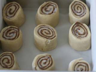 8、肉桂卷,放在8寸蛋糕模里进行二发。大概40分钟左右。表面刷点牛奶。