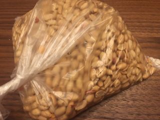 2、花生糖牛扎糖,将花生用保鲜袋装好，敲碎