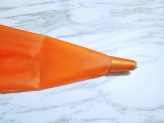 12、原味曲奇饼干,准备裱花袋,和裱花嘴,将裱花嘴放入裱花袋里。