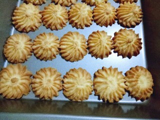 16、原味曲奇饼干,饼干烤好后,戴上隔热手套取出烤盘,这时先不要去碰触,因为刚出炉的饼干有些软,这时去碰它容易碎裂。