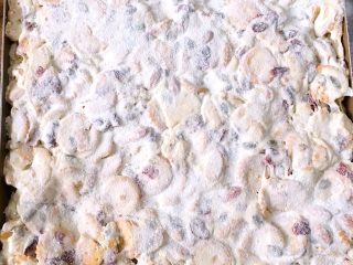 13、台湾网红零食雪花饼,放入方盘里，按着铺满方盘，用擀面杖擀平，撒上脱脂奶粉防黏，室温放置完全冷却