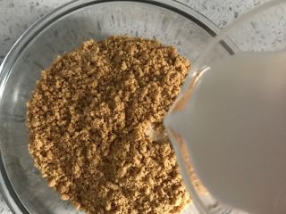 1、百香果芝士蛋糕,消化饼干压碎,加入牛奶