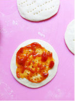 4、鲜虾迷你披萨,扎孔，抹上番茄酱