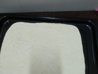 7、鸡肉披萨,醒发后，用擀面杖擀成方形或圆形，不能过厚，在用牙签在面上扎小孔，如图。