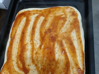 11、鸡肉披萨,将披萨酱均匀的抹在披萨皮上。