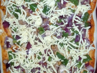 12、鸡肉披萨,先均匀的撒些芝士，再将炒好的菜放上去，再将剩余的芝士撒上去，最后撒上披萨草，放入烤箱20分钟。