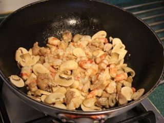 7、法式咸派 QUICHE,依序将切丁的鸡腿肉、鲜虾、蘑菇片放入锅内炒至略熟。加盐、胡椒、七味粉调味。