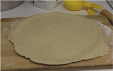 2、彩椒牛肉披萨,在案板上将面团擀成偏圆形