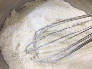 6、柠檬司康,均匀以后,加上牛奶和蜂蜜。再用刮刀搅拌均匀。