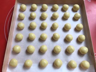 14、果酱饼干,搓成36个小球,放入铺了油纸的烤盘里。