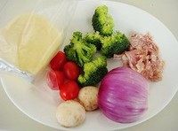 1、土司披萨,西兰花撕成小朵，口蘑切片，用开水焯一下。小西红柿切片。马苏里拉奶酪切小片，洋葱切丝